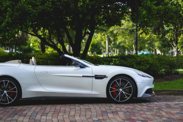 Aston Martin convertible putih diparkir di dekat pohon